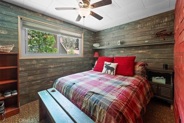 33019 Juniper Ln, Green Valley Lake, CA 92341 - bedroom featuring wooden walls, carpet flooring, and a ceiling fan