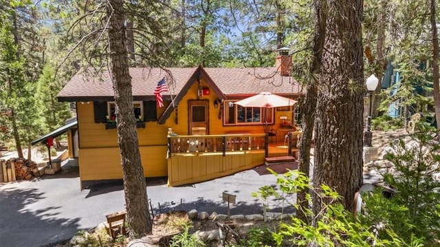 33019 Juniper Ln, Green Valley Lake, CA 92341 - back of house with a chimney, a shingled roof, and a deck