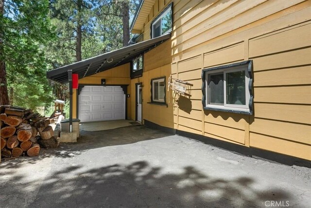 33019 Juniper Ln, Green Valley Lake, CA 92341 - view of side of home featuring asphalt driveway and an attached garage