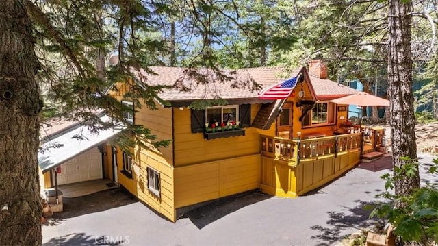33019 Juniper Ln, Green Valley Lake, CA 92341 - view of front of house featuring a garage, a chimney, and driveway
