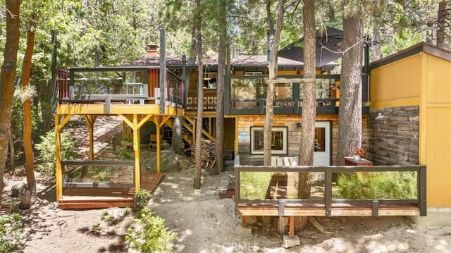 33019 Juniper Ln, Green Valley Lake, CA 92341 - back of house with a wooden deck, stone siding, and a chimney