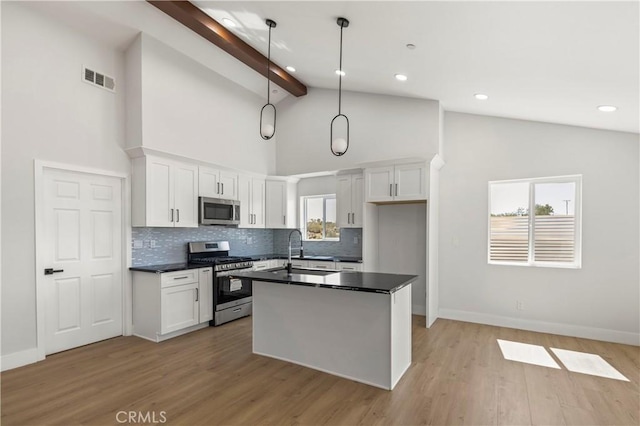 58424 Canterbury St, Yucca Valley, CA 92284 - kitchen with appliances with stainless steel finishes, dark countertops, backsplash, white cabinetry, and beamed ceiling