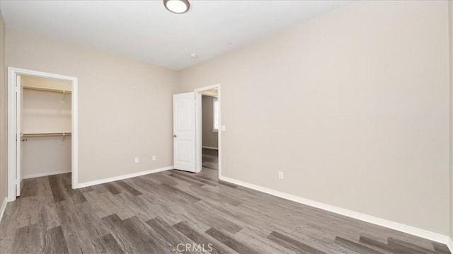 5120 Armendarez Ln, Fontana, CA 92336 - unfurnished bedroom featuring wood finished floors, a spacious closet, and a closet