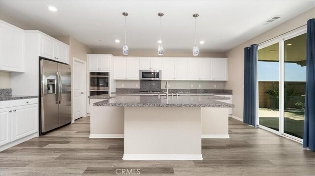 5120 Armendarez Ln, Fontana, CA 92336 - kitchen with appliances with stainless steel finishes, a kitchen island with sink, light wood-style floors, white cabinets, and recessed lighting