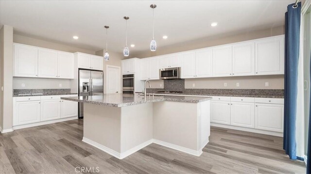 5120 Armendarez Ln, Fontana, CA 92336 - kitchen with appliances with stainless steel finishes, light wood-style flooring, white cabinetry, and recessed lighting