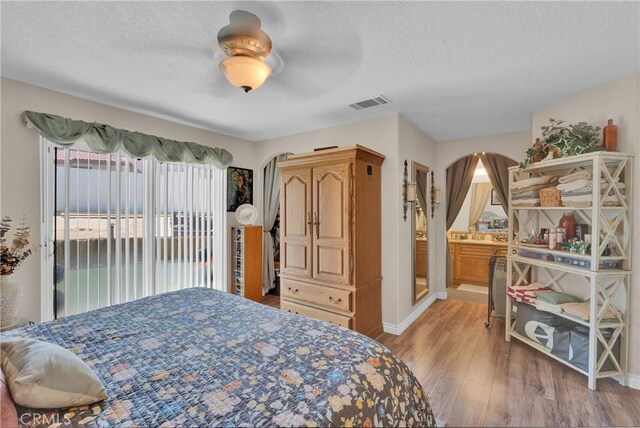 26460 Gem Ct, Helendale, CA 92342 - bedroom with wood finished floors, access to exterior, arched walkways, a textured ceiling, and ceiling fan
