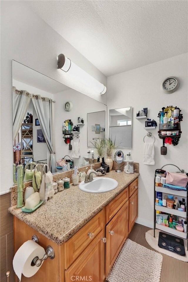 26460 Gem Ct, Helendale, CA 92342 - bathroom with a textured ceiling, vanity, and wood finished floors