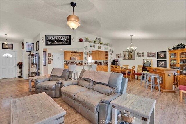 26460 Gem Ct, Helendale, CA 92342 - living room with a chandelier, lofted ceiling, light wood finished floors, and a textured ceiling