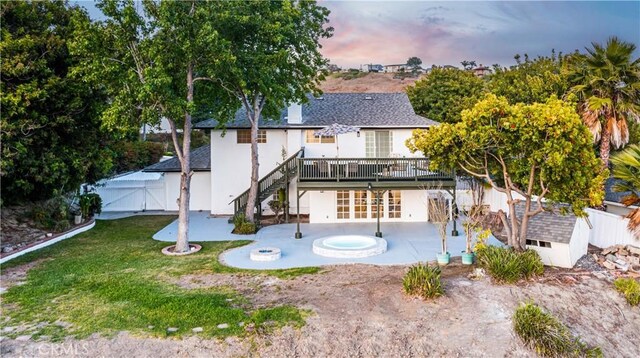 24135 Las Naranjas Dr, Laguna Niguel, CA 92677 - back of house at dusk with french doors, a patio area, a wooden deck, a gate, and roof with shingles