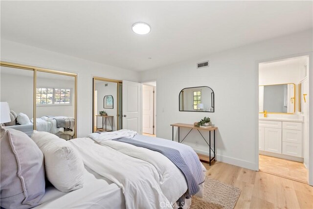 24135 Las Naranjas Dr, Laguna Niguel, CA 92677 - bedroom with light wood-type flooring, two closets, and connected bathroom