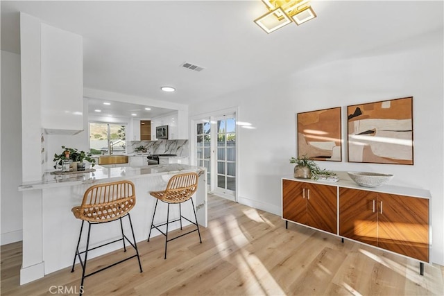 24135 Las Naranjas Dr, Laguna Niguel, CA 92677 - kitchen featuring white cabinetry, recessed lighting, appliances with stainless steel finishes, light wood-style flooring, and healthy amount of natural light