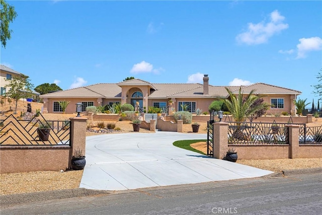 19420 Red Feather Rd, Apple Valley, CA 92307 - mediterranean / spanish house with a tiled roof, stucco siding, a chimney, and curved driveway