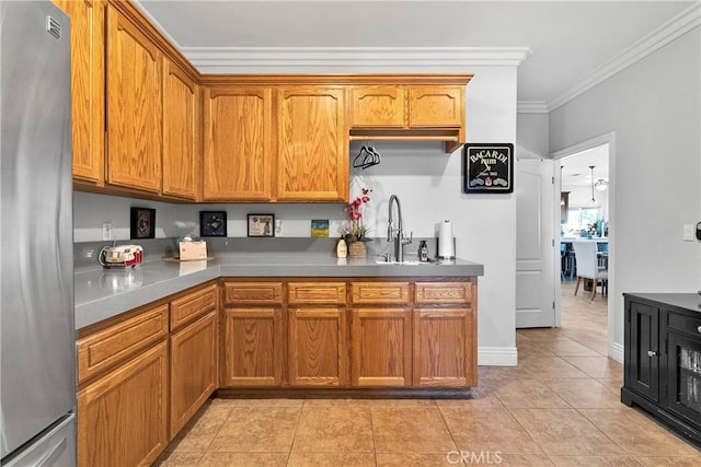 19420 Red Feather Rd, Apple Valley, CA 92307 - kitchen featuring freestanding refrigerator, crown molding, brown cabinets, and light tile patterned flooring