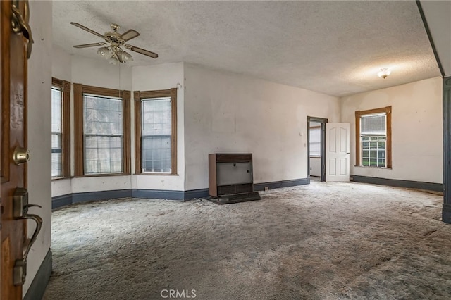 707 Marin St, Corning, CA 96021 - unfurnished living room featuring carpet, a textured ceiling, ceiling fan, and healthy amount of natural light