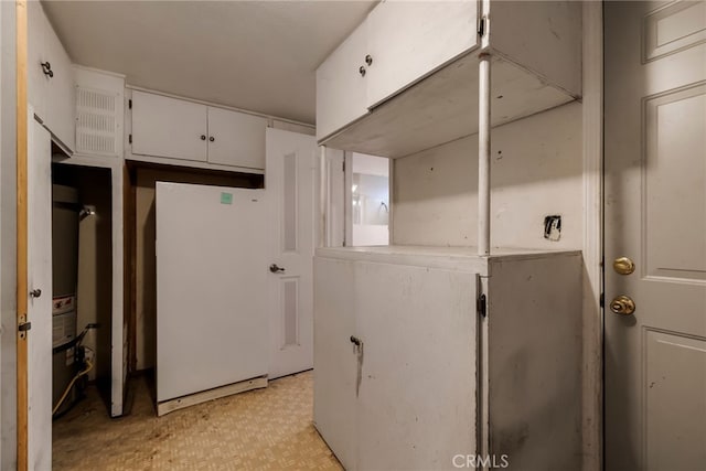 707 Marin St, Corning, CA 96021 - kitchen with white cabinets, freestanding refrigerator, and light floors