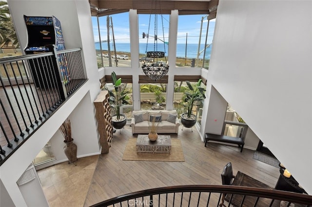 5390 Carlsbad Blvd, Carlsbad, CA 92008 - living area with a high ceiling, a water view, a chandelier, and wood finished floors