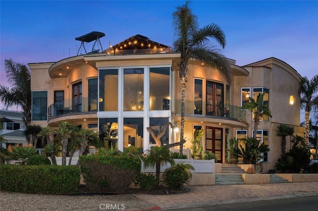 5390 Carlsbad Blvd, Carlsbad, CA 92008 - back of property at dusk with a balcony and stucco siding