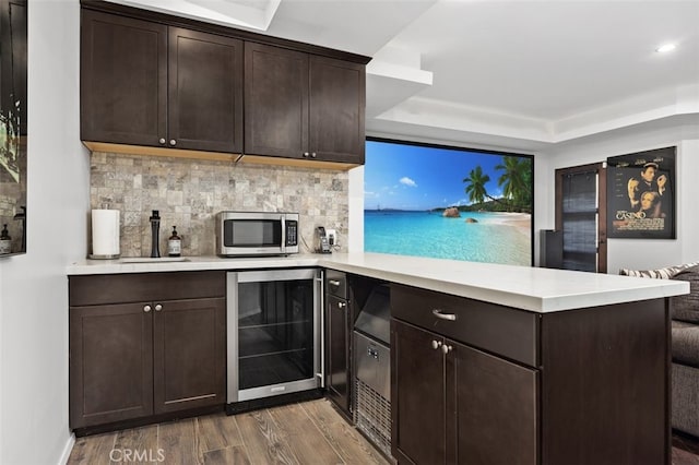 5390 Carlsbad Blvd, Carlsbad, CA 92008 - bar area featuring beverage cooler, wood finished floors, stainless steel microwave, a raised ceiling, and decorative backsplash