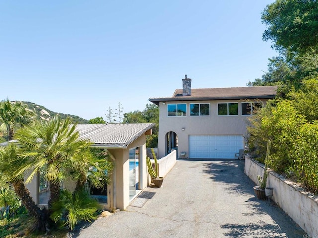 46920 Rainbow Canyon Rd, Temecula, CA 92592 - view of front of property with stucco siding, asphalt driveway, an attached garage, and a chimney