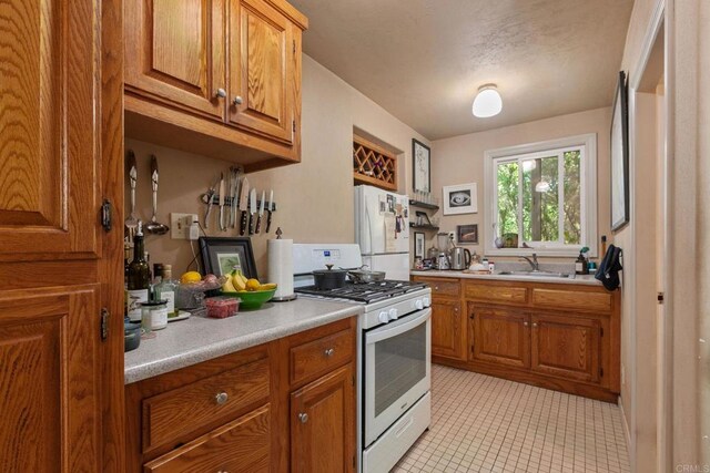 46920 Rainbow Canyon Rd, Temecula, CA 92592 - kitchen featuring white appliances, brown cabinets, light countertops, and light tile patterned floors