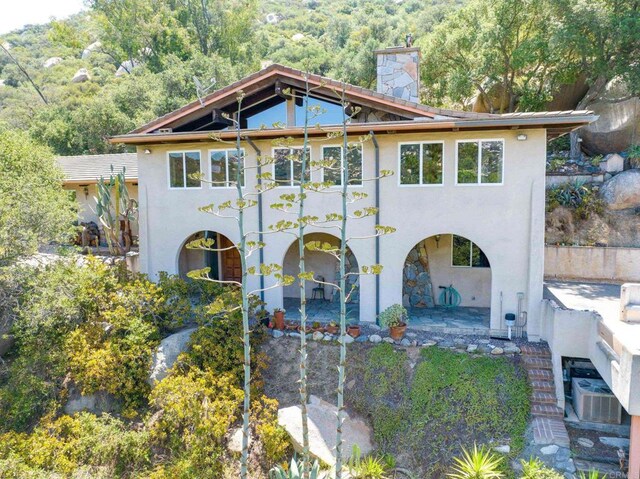 46920 Rainbow Canyon Rd, Temecula, CA 92592 - back of house featuring stucco siding, a chimney, a view of trees, a balcony, and a patio