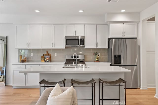 305 Blackrock, Lake Forest, CA 92610 - kitchen featuring appliances with stainless steel finishes, light countertops, white cabinets, light wood-type flooring, and recessed lighting