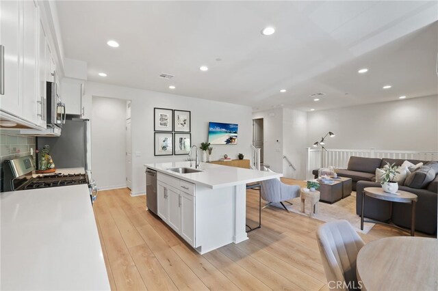 305 Blackrock, Lake Forest, CA 92610 - kitchen with appliances with stainless steel finishes, open floor plan, white cabinetry, recessed lighting, and a center island with sink