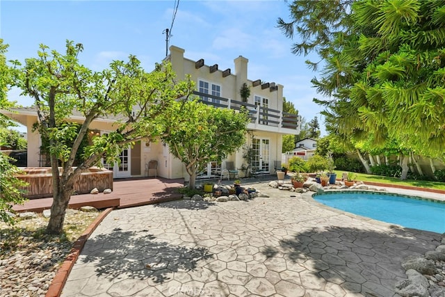 8601 Rudnick Ave, West Hills, CA 91304 - rear view of house with french doors, stucco siding, a balcony, a patio area, and an outdoor pool