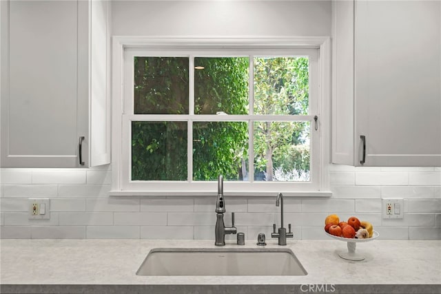 8601 Rudnick Ave, West Hills, CA 91304 - kitchen with backsplash, white cabinets, and light stone counters