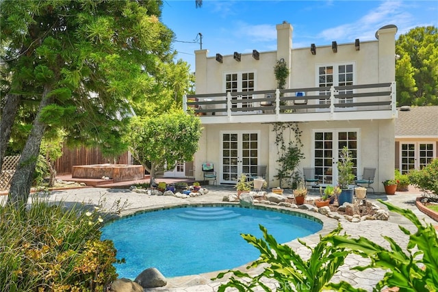 8601 Rudnick Ave, West Hills, CA 91304 - rear view of house featuring french doors, a balcony, stucco siding, an outdoor pool, and a patio area
