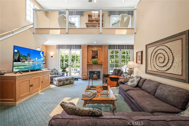 8601 Rudnick Ave, West Hills, CA 91304 - living area with carpet, a high ceiling, french doors, plenty of natural light, and a lit fireplace