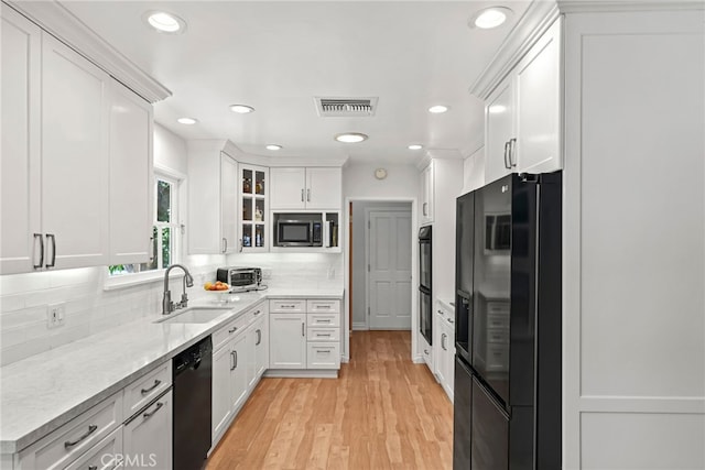 8601 Rudnick Ave, West Hills, CA 91304 - kitchen featuring black appliances, backsplash, white cabinets, light wood finished floors, and glass insert cabinets