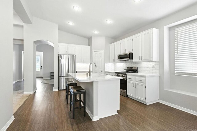 46076 Via Ln, Colorada, Temecula, CA 92592 - kitchen featuring appliances with stainless steel finishes, arched walkways, tasteful backsplash, white cabinets, and recessed lighting