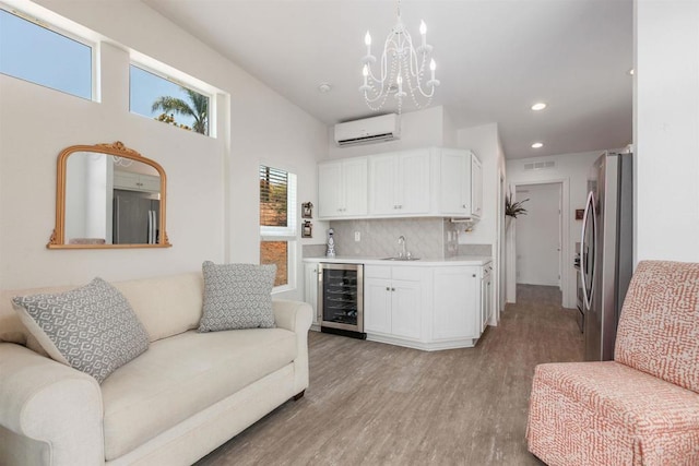 2149 Gamble Pl, Escondido, CA 92029 - living room with wine cooler, wet bar, a wall unit AC, light wood-style floors, and a chandelier