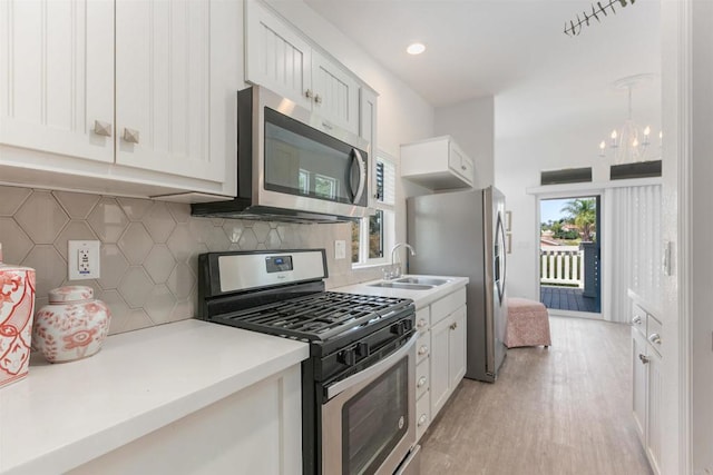 2149 Gamble Pl, Escondido, CA 92029 - kitchen featuring appliances with stainless steel finishes, tasteful backsplash, light wood-style floors, light countertops, and a chandelier