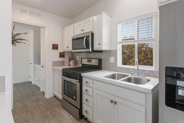 2149 Gamble Pl, Escondido, CA 92029 - kitchen with appliances with stainless steel finishes, light countertops, white cabinetry, and decorative backsplash