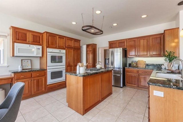 2149 Gamble Pl, Escondido, CA 92029 - kitchen with stainless steel appliances, a kitchen island, dark stone counters, recessed lighting, and light tile patterned floors