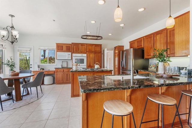 2149 Gamble Pl, Escondido, CA 92029 - kitchen featuring white appliances, brown cabinets, a peninsula, dark stone counters, and recessed lighting