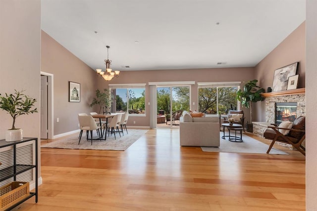 2149 Gamble Pl, Escondido, CA 92029 - living area featuring plenty of natural light, a chandelier, a stone fireplace, light wood-type flooring, and vaulted ceiling