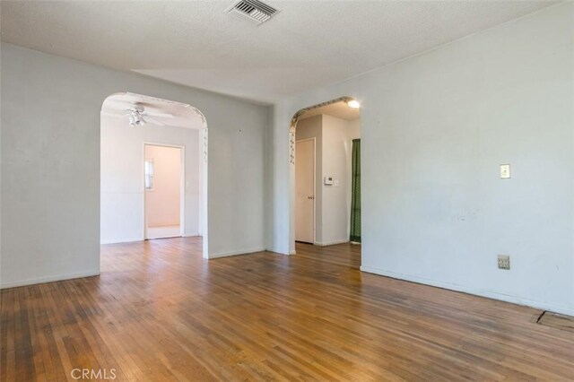 15300 Mayall St, San Fernando, CA 91345 - spare room featuring arched walkways, wood finished floors, and ceiling fan
