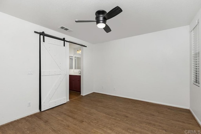 1837 Olive Green St Unit 3, Chula Vista, CA 91913 - unfurnished bedroom featuring a barn door, wood finished floors, ensuite bath, and a ceiling fan
