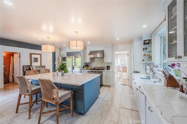 26767 Shadow Wood Dr, Rancho Palos Verdes, CA 90275 - kitchen featuring wall chimney range hood, high quality appliances, decorative backsplash, white cabinets, and pendant lighting