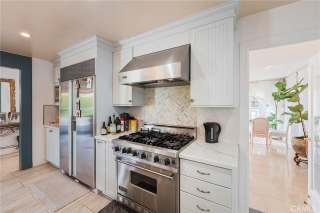 26767 Shadow Wood Dr, Rancho Palos Verdes, CA 90275 - kitchen featuring wall chimney range hood, high end appliances, decorative backsplash, white cabinetry, and recessed lighting