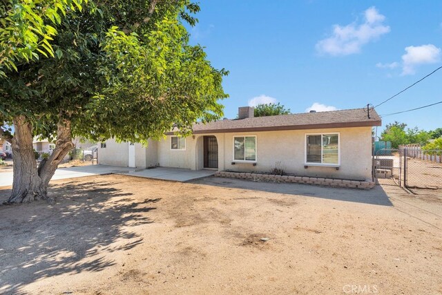 10723 Portland Ave, Hesperia, CA 92345 - view of front of house featuring a gate, stucco siding, and a patio