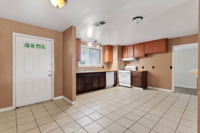 10723 Portland Ave, Hesperia, CA 92345 - kitchen with white appliances, light countertops, under cabinet range hood, and light tile patterned flooring