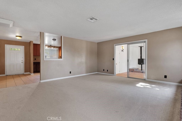 10723 Portland Ave, Hesperia, CA 92345 - unfurnished room with light colored carpet, a textured ceiling, and light tile patterned flooring