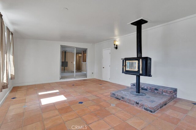 10723 Portland Ave, Hesperia, CA 92345 - unfurnished living room featuring a wood stove and tile patterned floors
