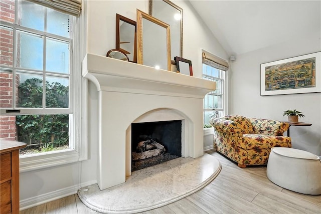 11832 Weatherby Rd, Los Alamitos, CA 90720 - living area with vaulted ceiling, wood finished floors, and a fireplace with raised hearth