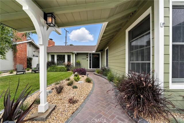 11832 Weatherby Rd, Los Alamitos, CA 90720 - view of exterior entry with a yard