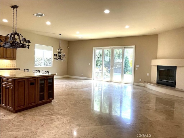 2068 Radnor Ave, Long Beach, CA 90815 - kitchen with a chandelier, recessed lighting, open floor plan, a glass covered fireplace, and pendant lighting